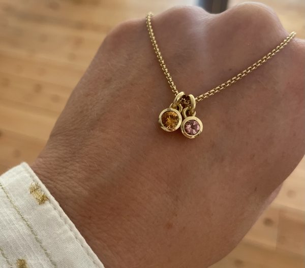 orangefarbener Saphir in 750/-Gelbgold mit einem Brillanten