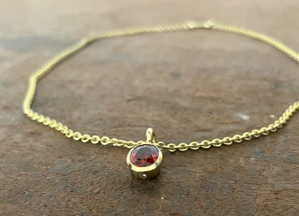 Mandarin Granat in 750/-Gelbgold mit einem Brillanten
