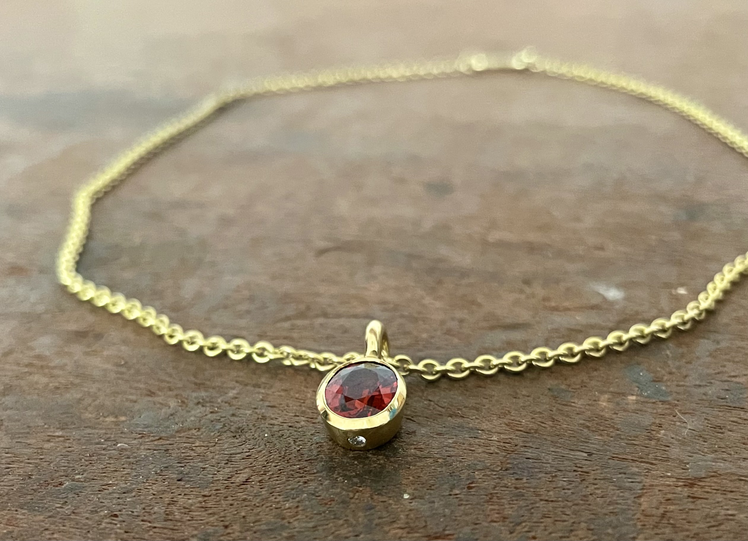 Mandarin Granat in 750/-Gelbgold mit einem Brillanten