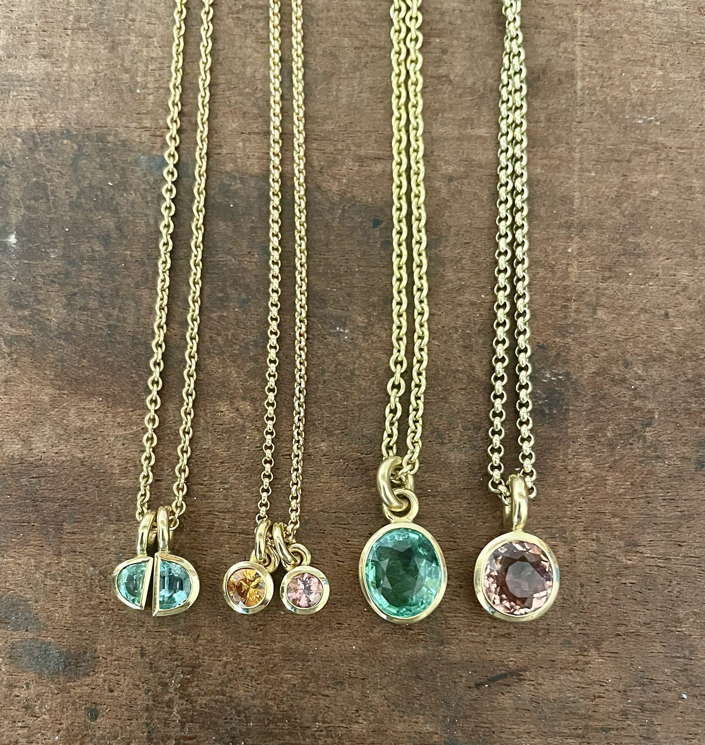 Handgefertigte Anhänger. Facettierte Turmaline und ein orangefarbener Saphir, gefertigt in 750/-Gelbgold.