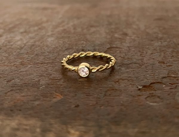gedrehter Ring in 750/-Gelbgold mit einem rosa Saphir